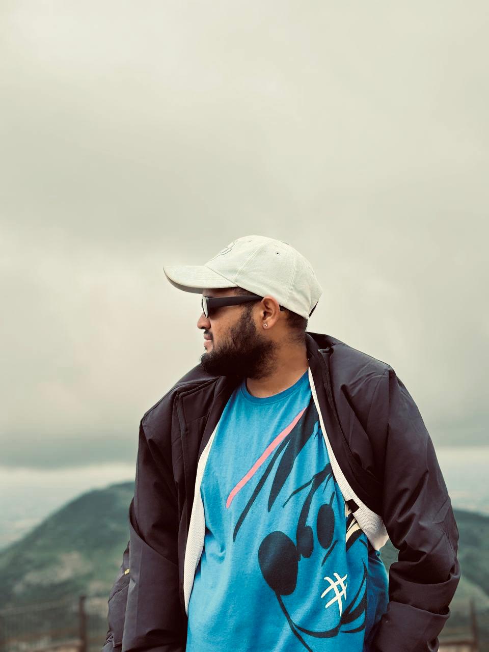 Dhanush P. Soorya in profile against a hilly landscape.