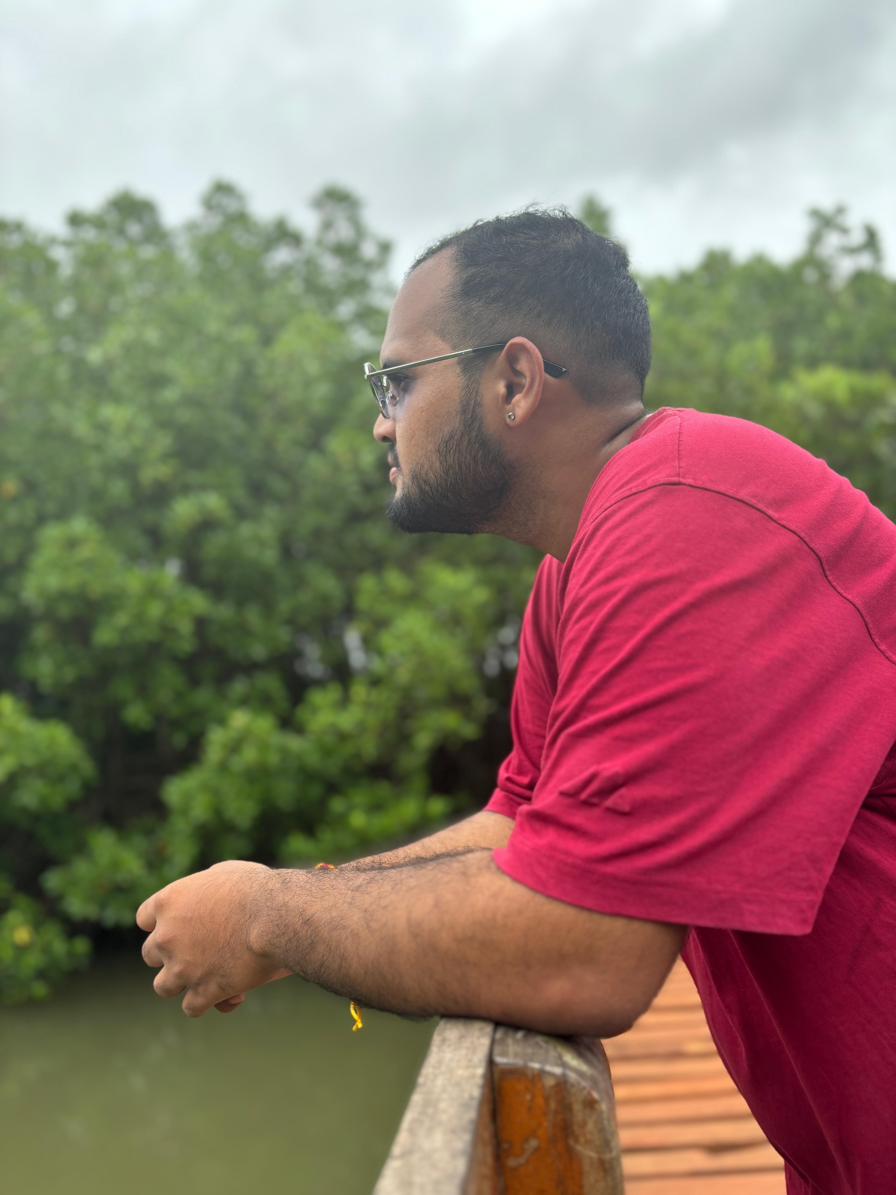 Dhanush P. Soorya looking out over trees and water.